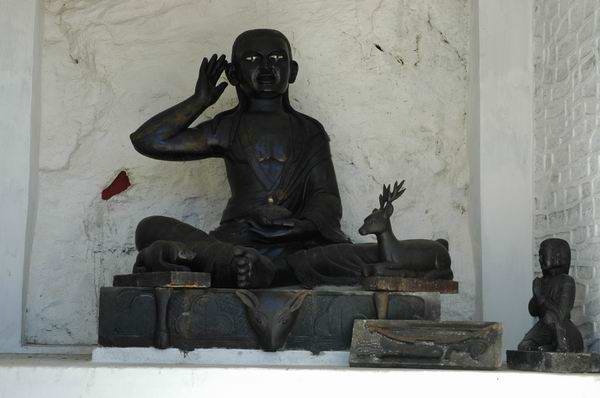 8 foot statue of Milarepa, the hunter, the dog and the deer.