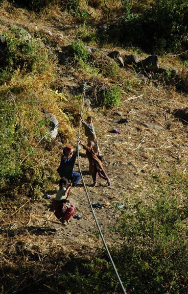 These local children are having fun swinging on the cables supporting the bridge we are about to cross