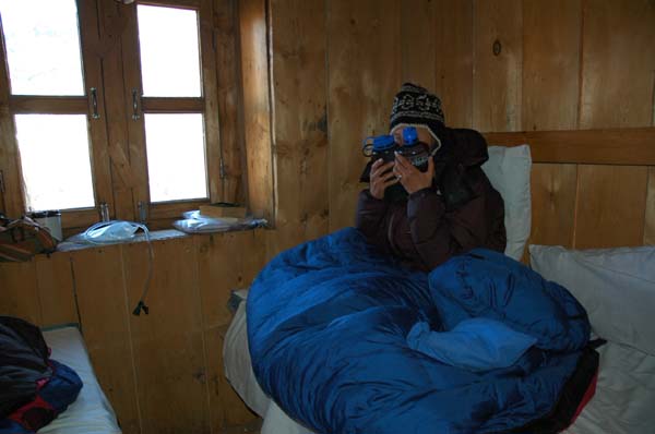 Lauri trys to warm up with two hot water bottles, a down jacket, sleeping bag, and several layers of fleece clothing